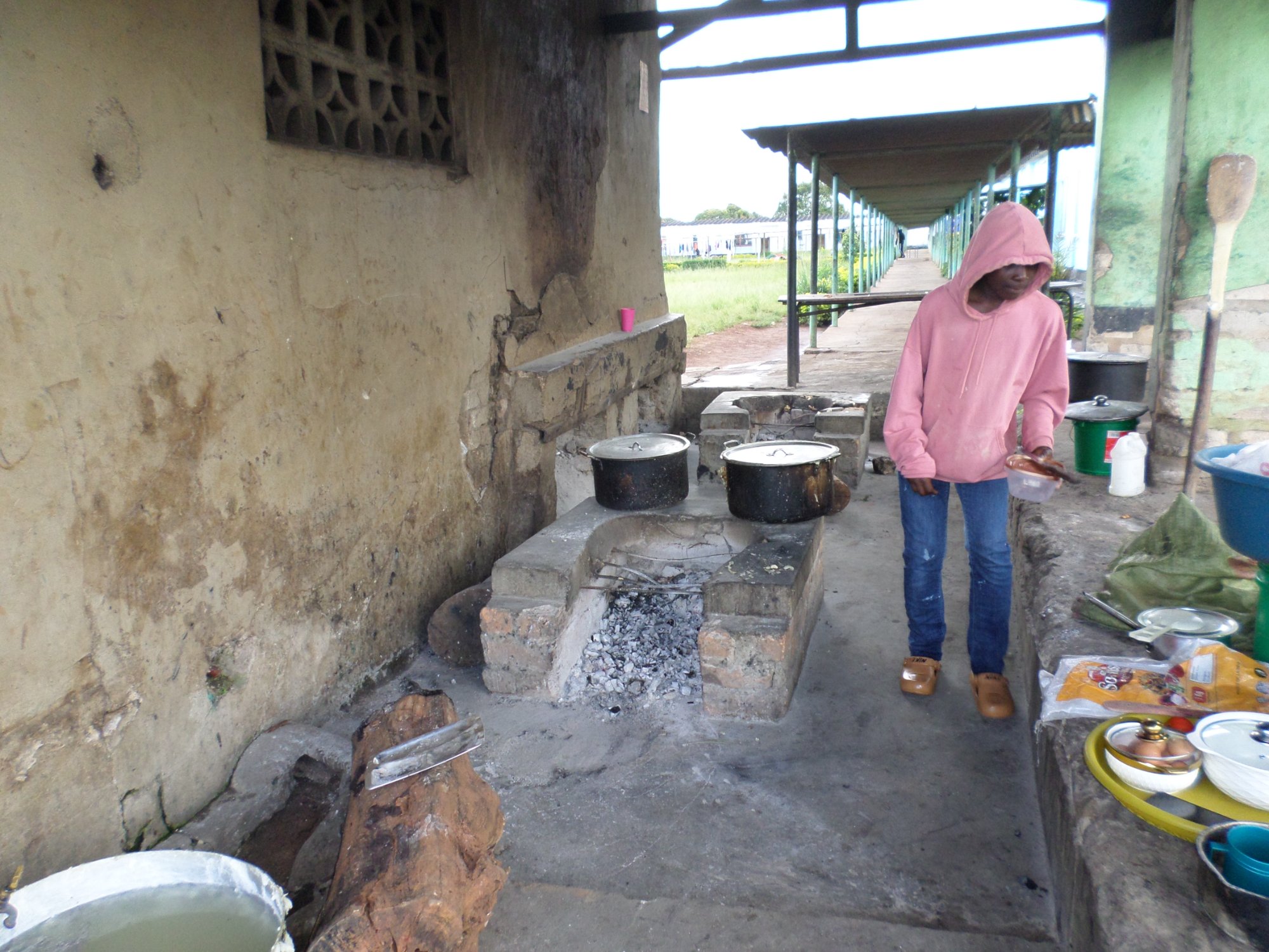 School cook preparing meals in the open-air kitchen